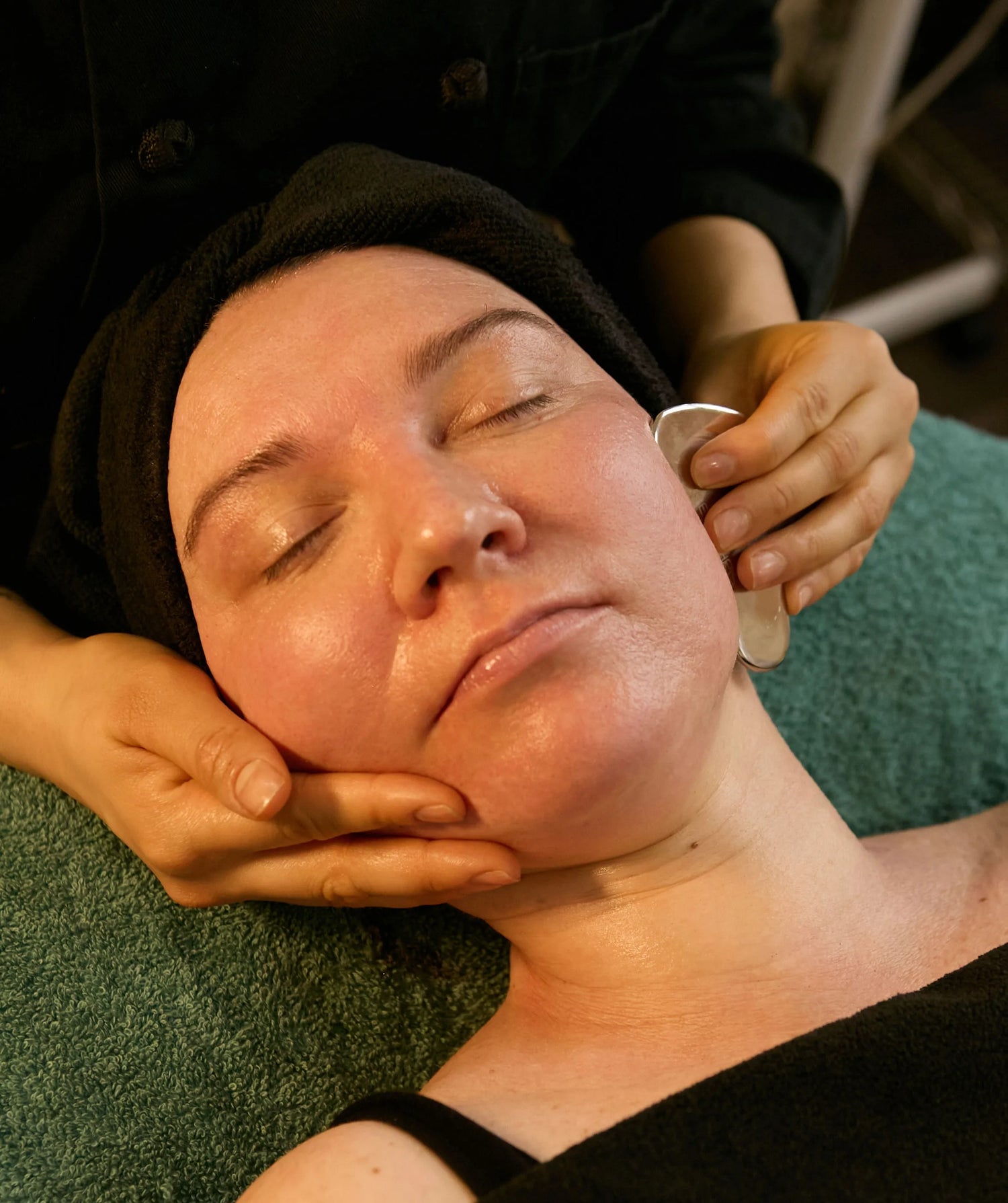 Maison OKOKO esthetician performing jaw sculpting and lymphatic facial massage to release tension and restore facial definition