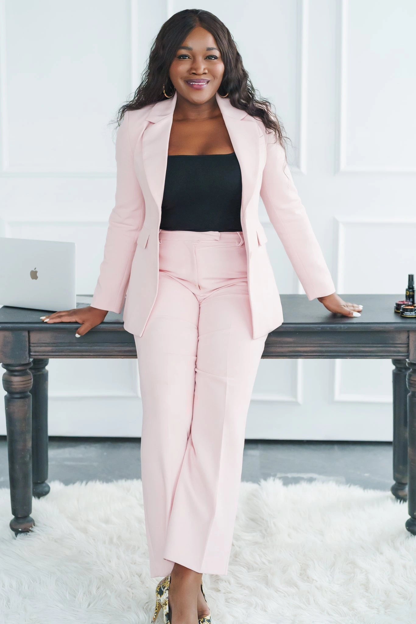Oyéta Kokoroko, founder and creative director of Maison OKOKO, photographed in a soft pink suit representing modern leadership, innovation, and global impact.