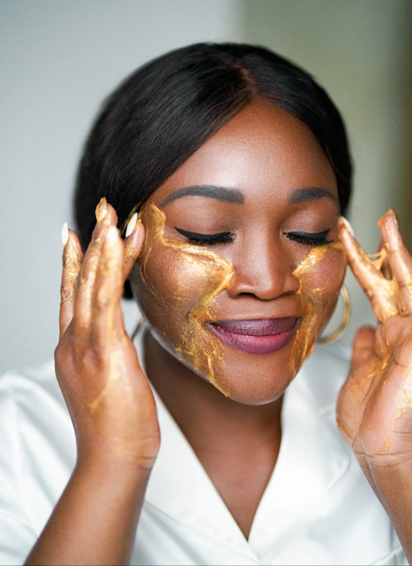 Oyeta Kokoroko, founder of Maison OKOKO, performing an intelligent luxury skincare ritual with her signature essence rare gold mask inside the Vancouver facial atelier.
